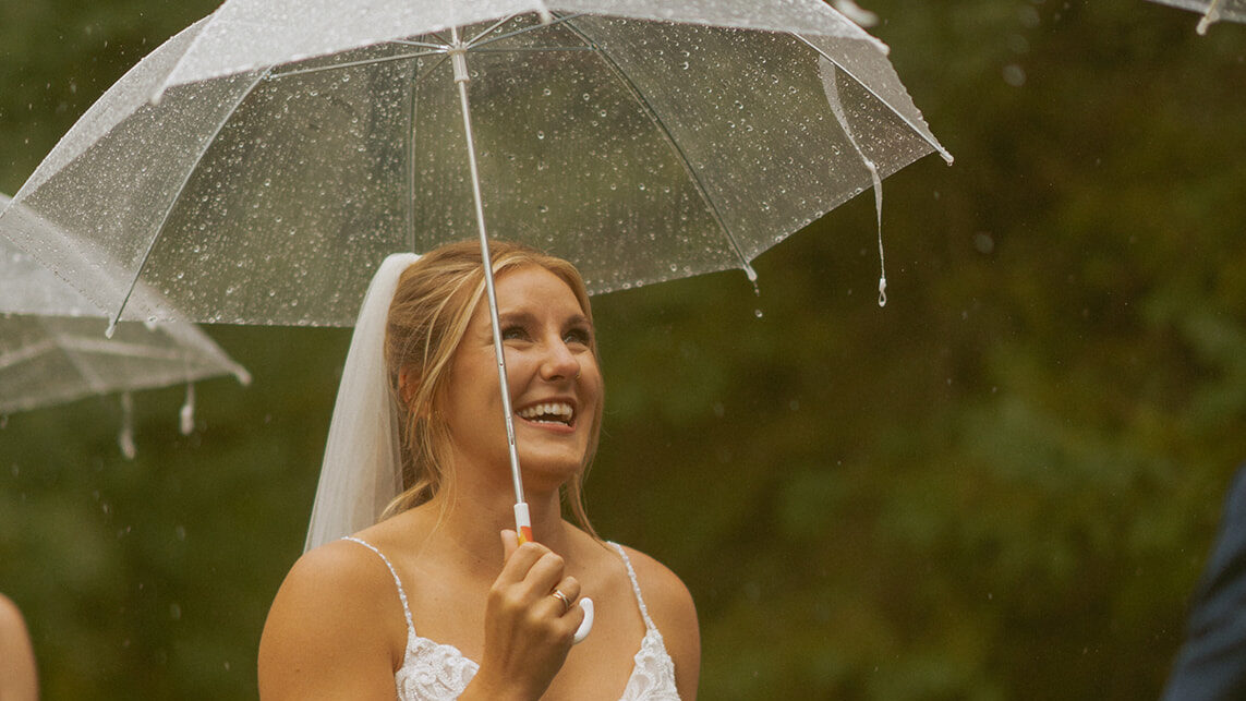 Bride Smiling at the rain falling during their wedding ceremony near Edson Alberta