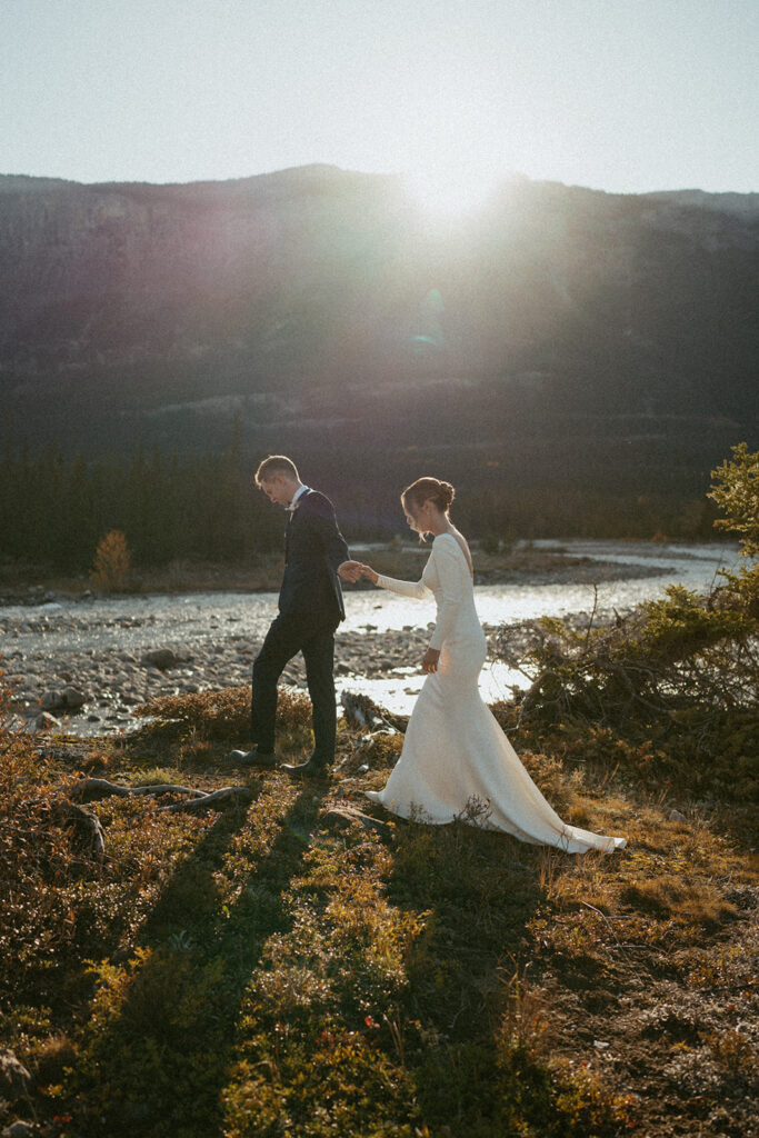 Bride and Groom walking near river in Jasper National Park