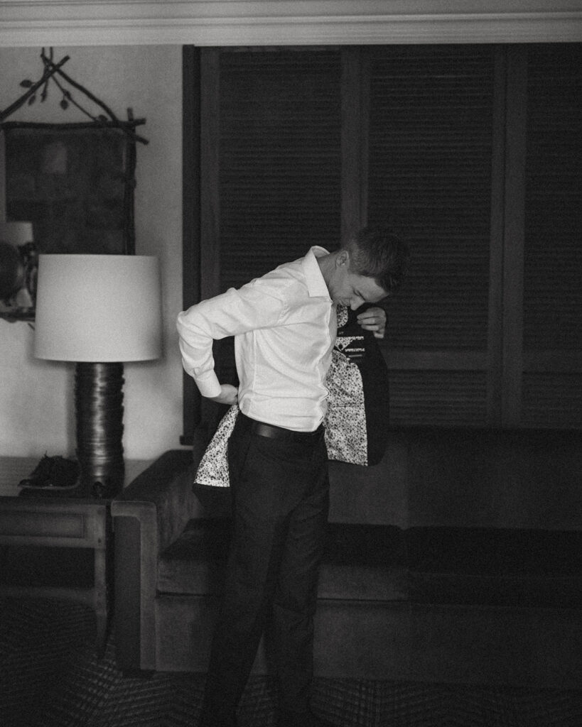 Groom putting on his suit before elopement