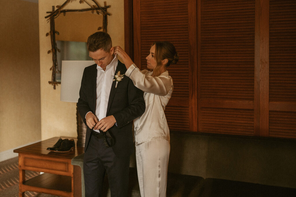 bride helping groom with suit before they elope in Jasper National Park
