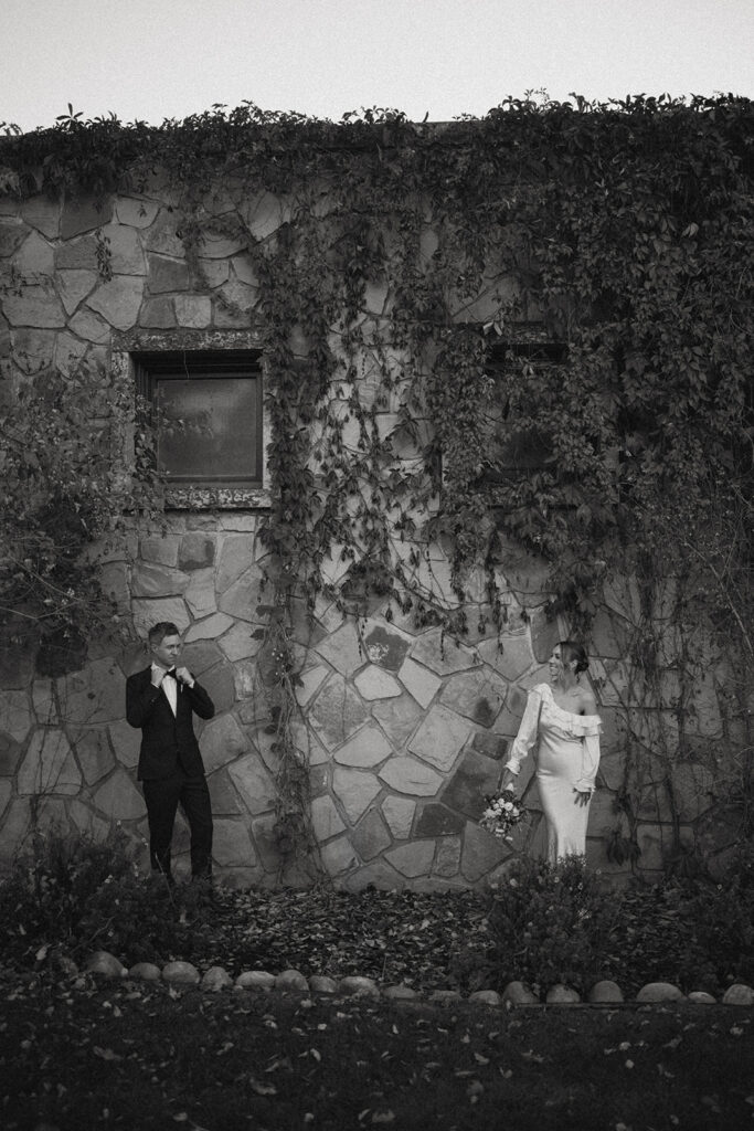 Photo of Bride and Groom in front of a building with vines at the fairmont jasper park lodge