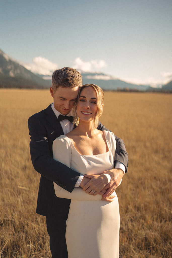 Bride and Groom Posing in a field in the fall in Jasper National Park
