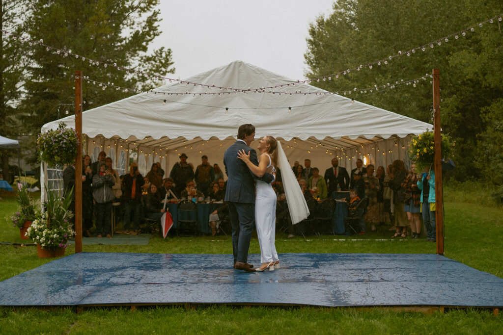 Bride and Groom First dance in the rain with twinkly outdoor lights at their country wedding near Edson Alberta.