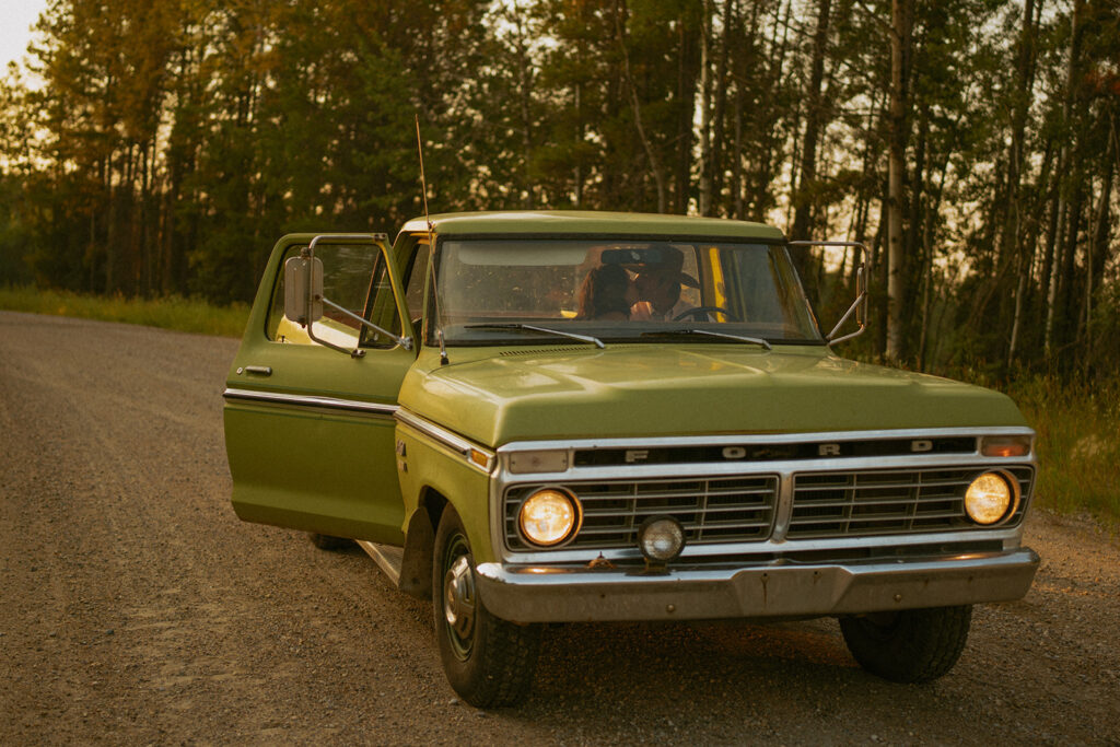 A Couple Kissing at Sunset inside of an old Green Ford Truck on a Dirt Road in Edson Alberta