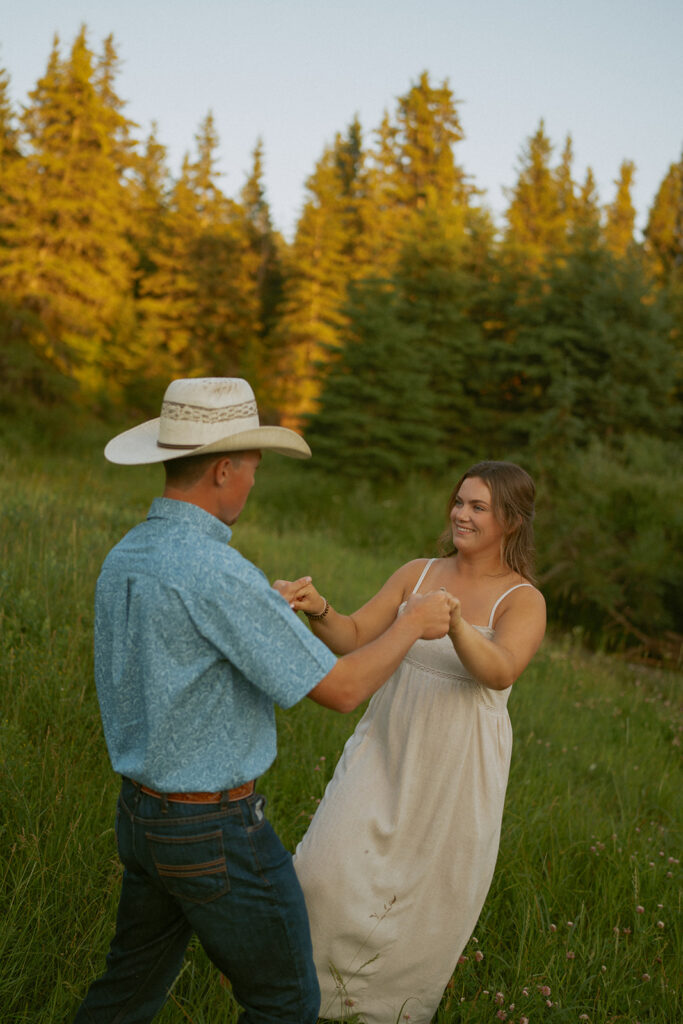 anniversary photoshoot couple dancing at sunset in a field of grass