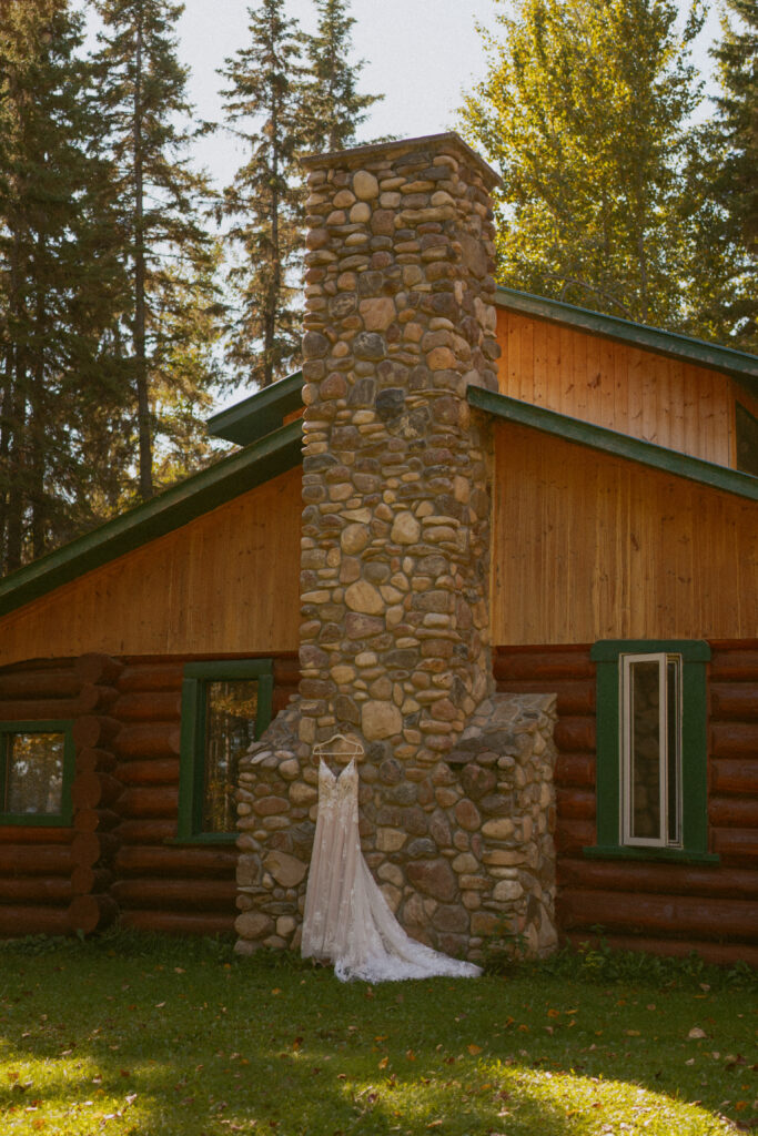 Photo of Dress hanging on cabin at Camp Maskepetoon Wedding