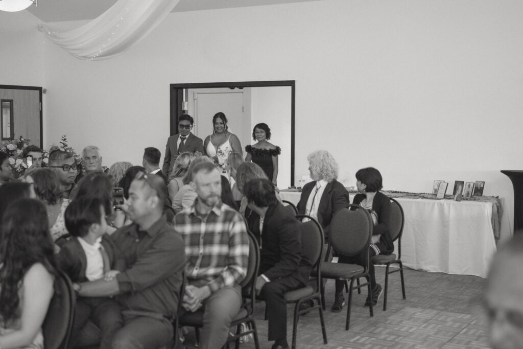 Bride entering the ceremony arm in arm with her parents at a Hinton Alberta wedding.