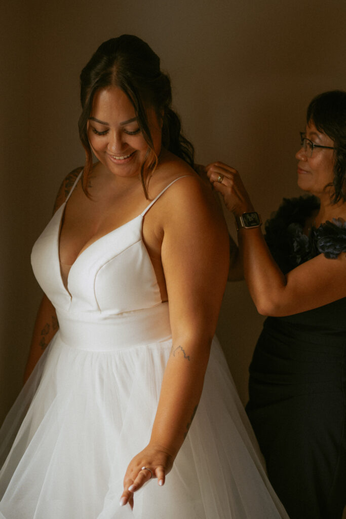 Mother helping the bride get ready before her Hinton Alberta wedding.