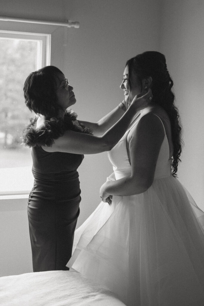 Mother helping the bride get ready before her Hinton Alberta wedding.
