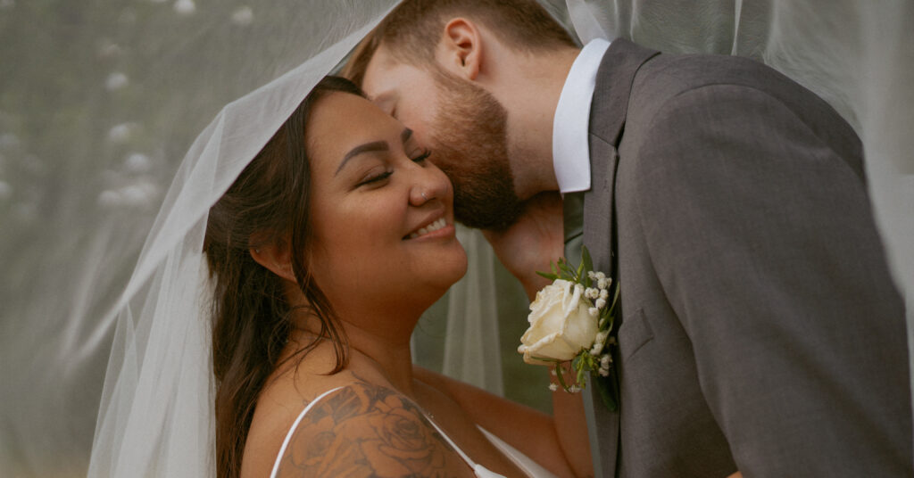 Tender portrait under the veil during Sean and Kayla’s Hinton Alberta wedding.