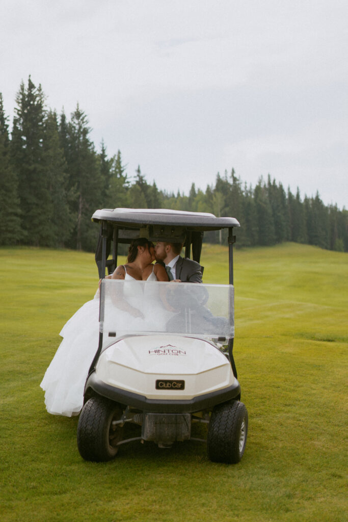Newlyweds riding a golf cart at their Hinton Alberta wedding.