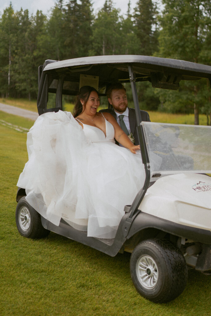 Newlyweds riding a golf cart at their Hinton Alberta wedding.