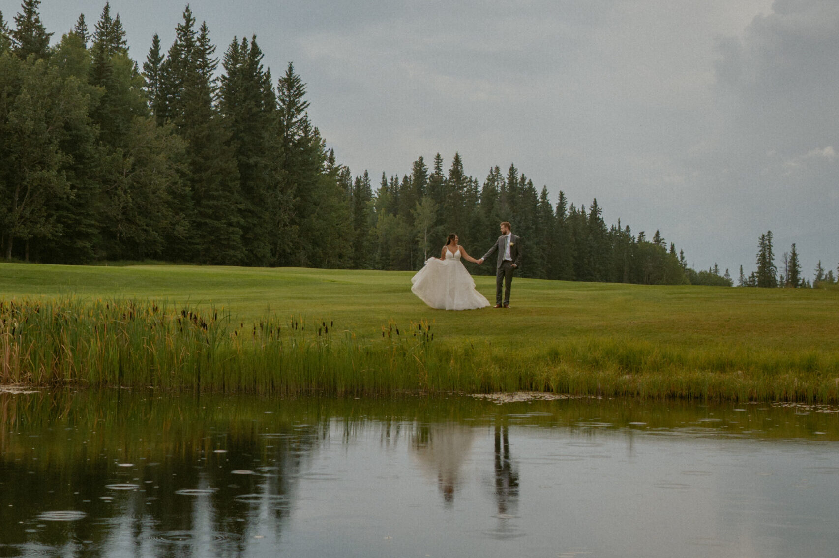 couple dancing near lake during Hinton Alberta Wedding