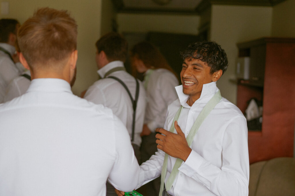 Groomsmen laughing and getting ready with cameras at a Hinton Alberta wedding.