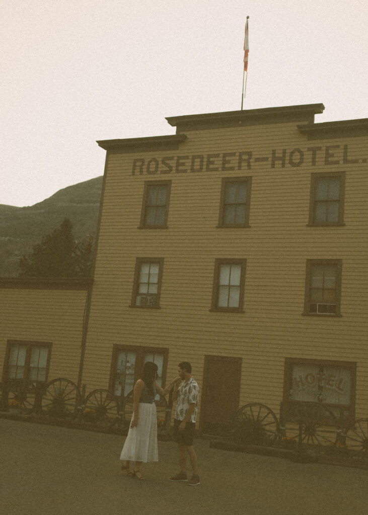 Jordyn and Liam outside the vintage Rosedeer Hotel captured by Drumheller wedding photographer during golden hour.