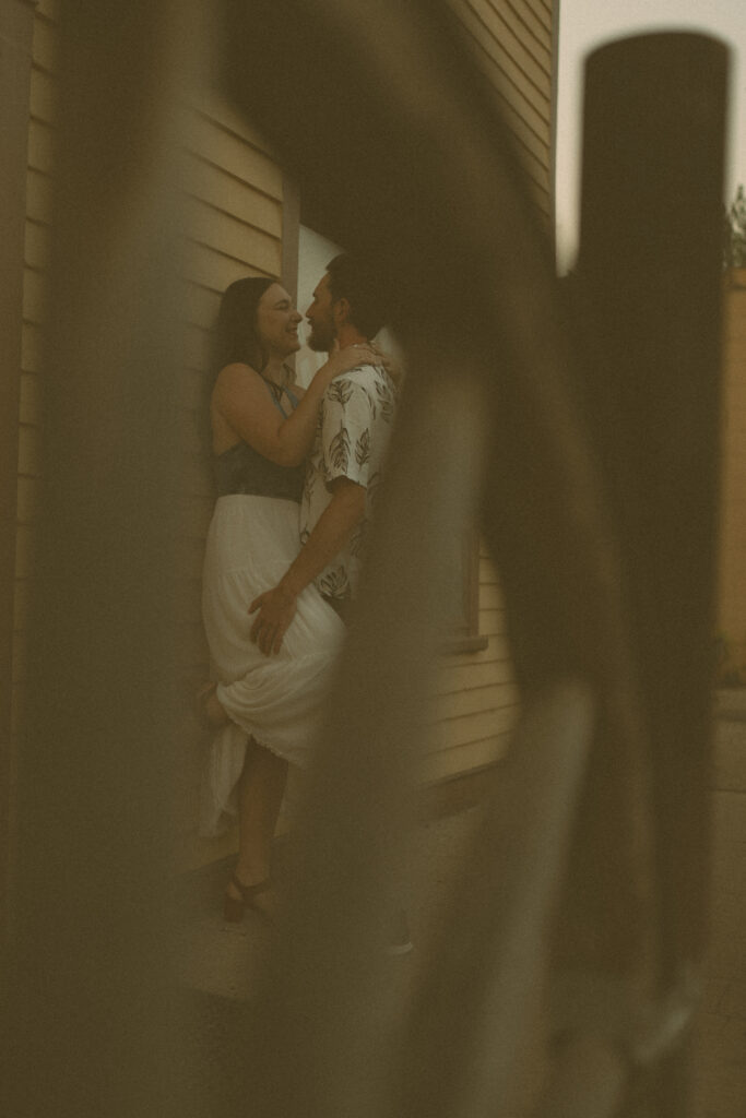 Intimate vintage-style photo through a wagon wheel by Drumheller wedding photographer in Wayne, Alberta.