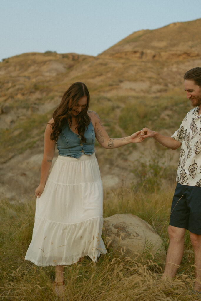 Joyful couple’s embrace at sunset in the Alberta badlands by Drumheller wedding photographer.