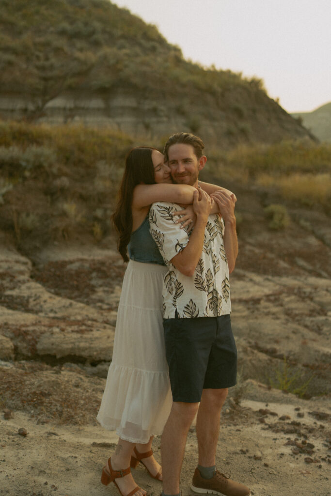 Joyful couple’s embrace at sunset in the Alberta badlands by Drumheller wedding photographer.