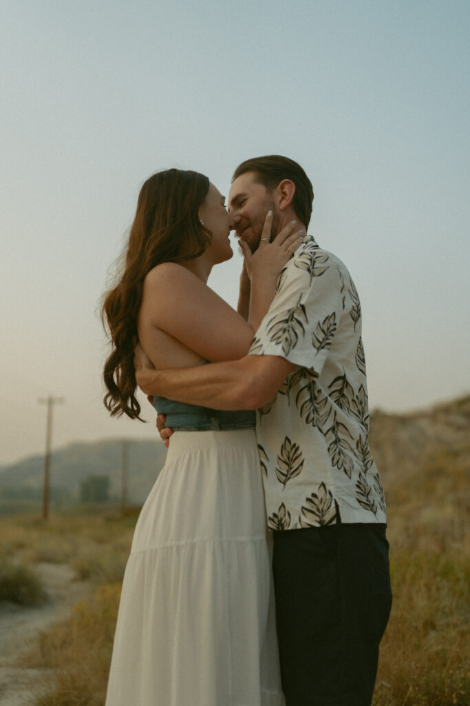 Romantic sunset kiss in the Alberta hoodoos by Drumheller wedding photographer Jordan’s Photos & Films.