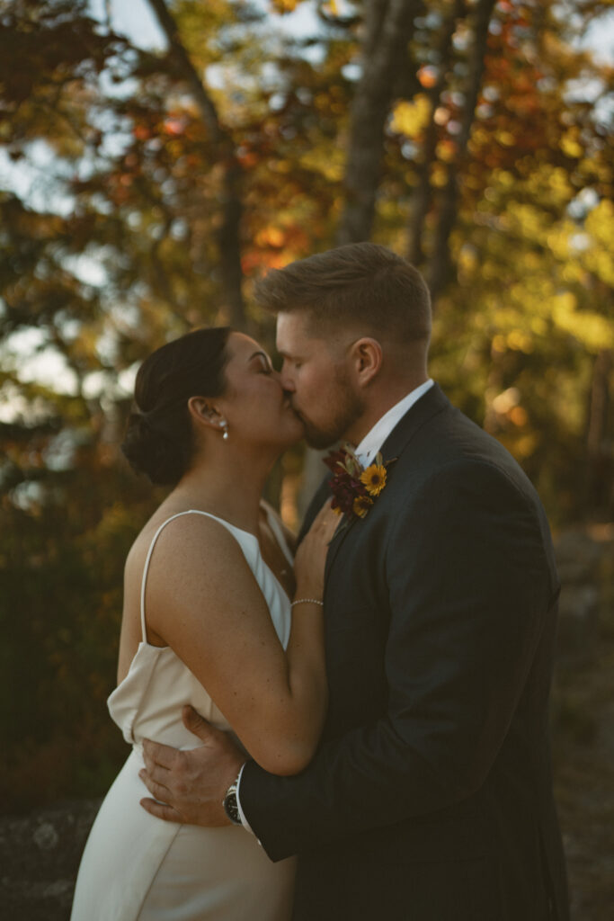 Sunset kiss at Acadia National Park wedding near the ocean cliffs.