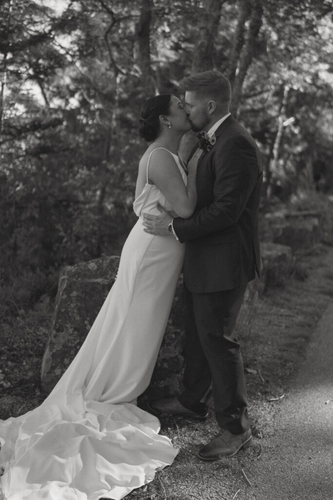 Sunset kiss at Acadia National Park wedding near the ocean cliffs.