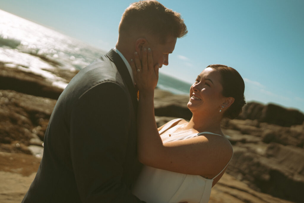 Sunset kiss at Acadia National Park wedding near the ocean cliffs.