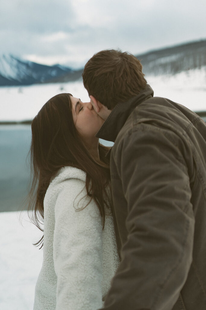Candid kiss captured in falling snow in the Canadian Rockies