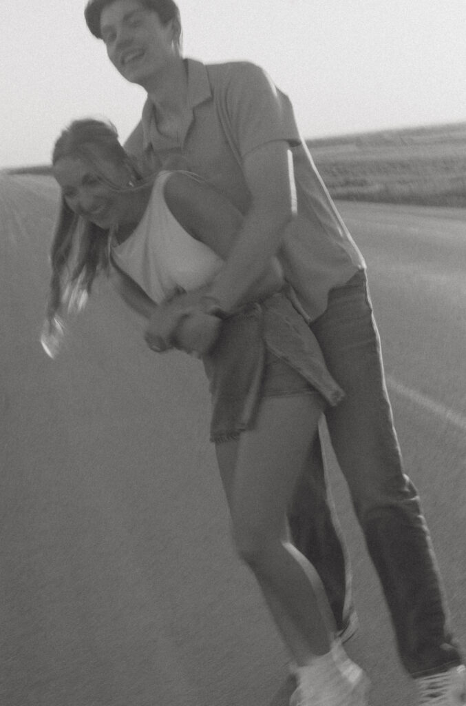 Couple embracing in warm sunset light during a nostalgic prairie couples session.