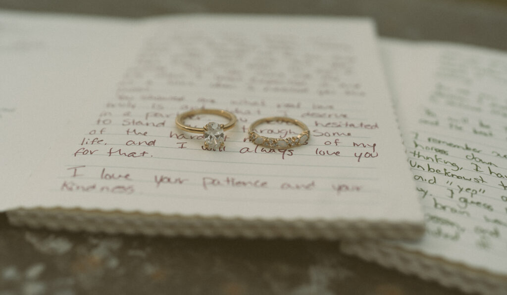 Wedding invitation suite, rings, blue bridal shoes, and stationery photographed on stone at Fairmont Jasper Park Lodge.