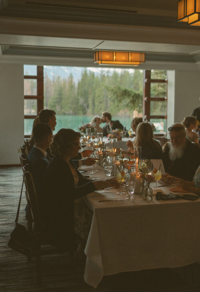 Elegant reception table decorated with candles and spring florals at Fairmont Jasper Park Lodge.
